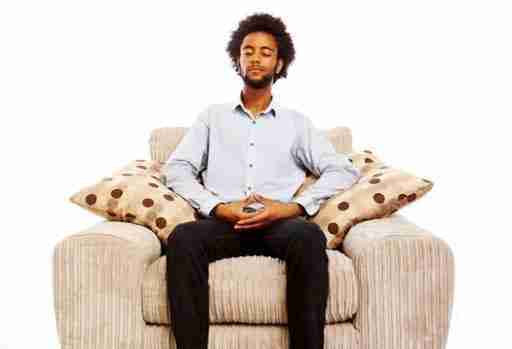 man meditating on seated comfortable chair
