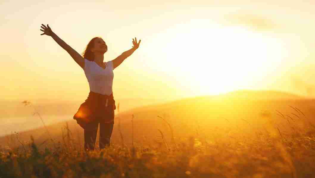 Happy woman in nature with sunshine