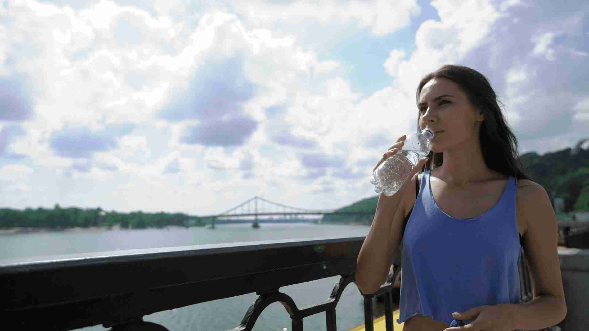 woman sipping on water bottle