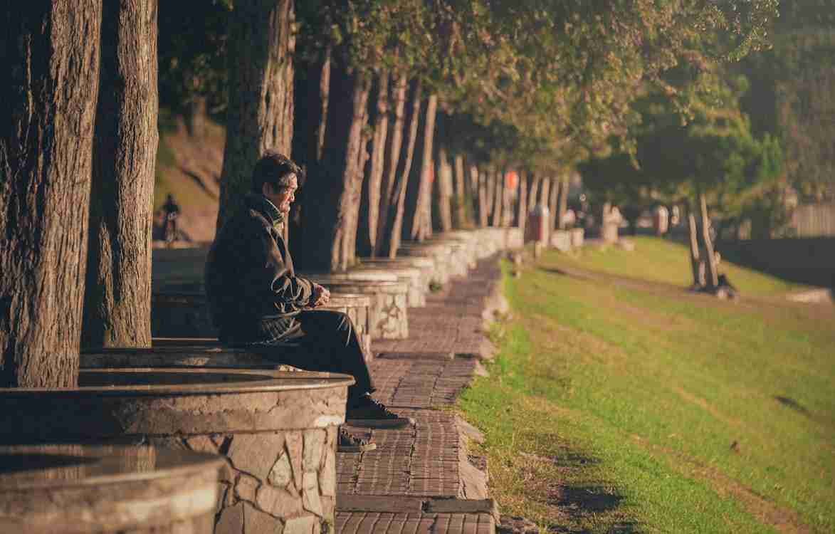 Free Man Seating on Concrete Base Stock Photo